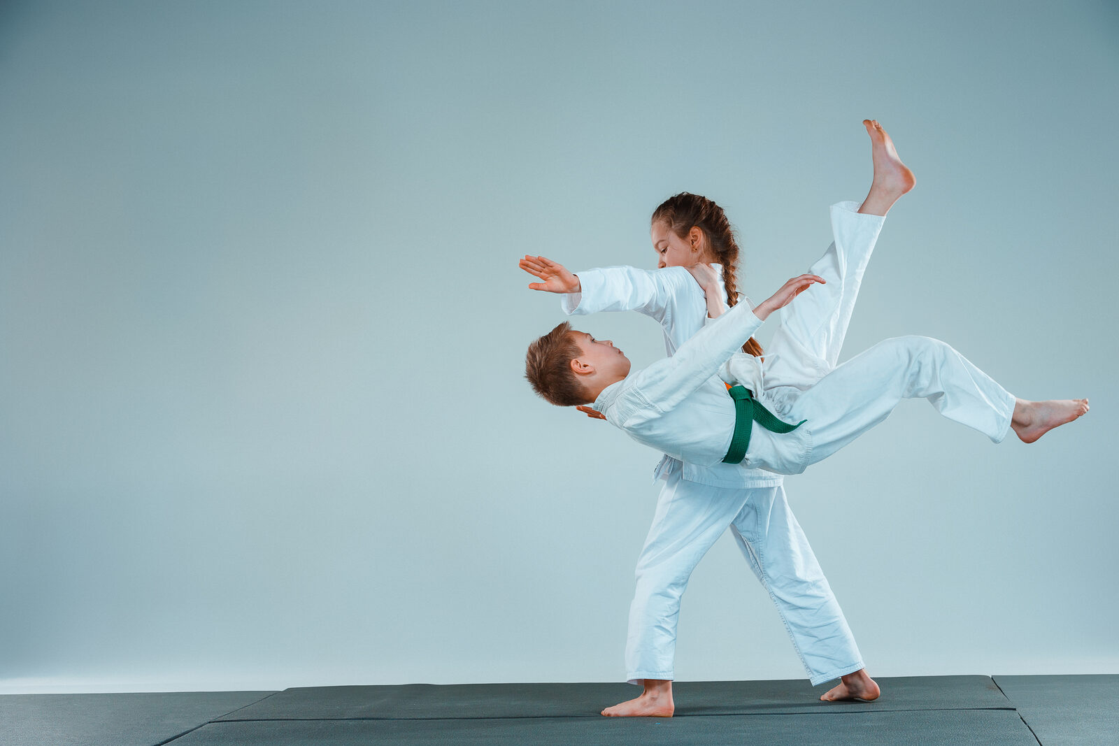 Young martial arts students practicing a throw together at Eugene Dojo kids class in Eugene Oregon