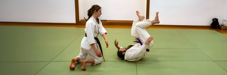 Youth martial arts student practicing a safe throw during teen class at Eugene Dojo